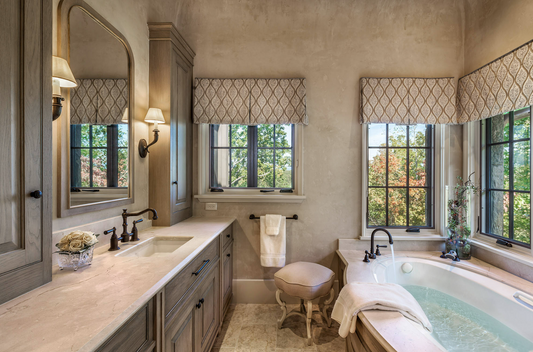 Bathroom with patterned board-mounted valances over windows above a freestanding bath
