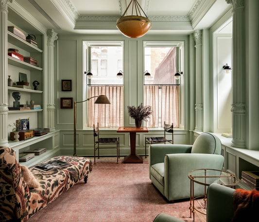 Sage green living room with patterned cafe curtains on the lower half of tall windows